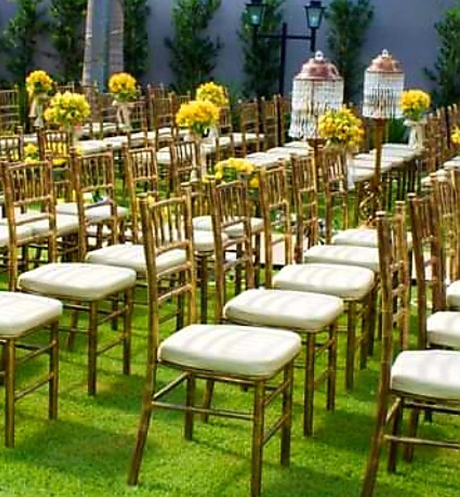Cerimônia de casamento com cadeiras tiffanys douradas.
